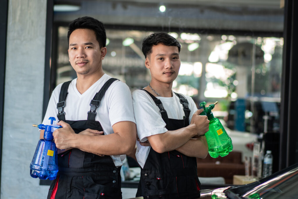 Portrait of Asian mechanic worker standing and holding spray bot